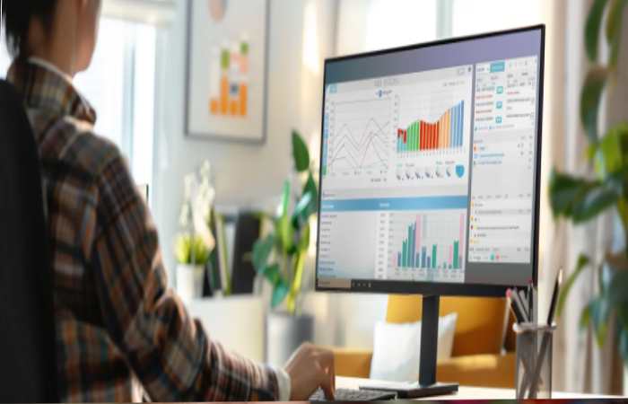 A person working at a desk with a computer monitor, optimizing sales cycles through automated follow-up capabilities.